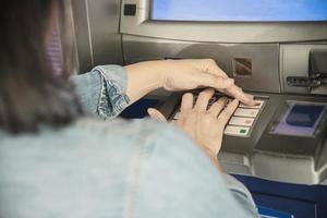 People waiting to get money from automated teller machine - people withdrawn money from ATM concept photo