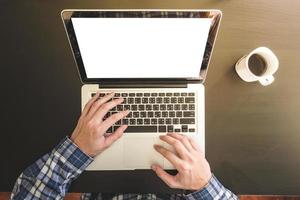 Top view of Male hands working on Laptop, Cup of coffee on the desk. photo