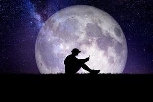 Concept of loneliness and disappointment in love. Sad man sitting element of the picture is decorated by NASA photo