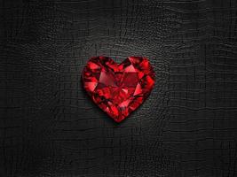 Red heart shaped diamond, on a black leather background photo