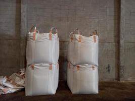 Large jumbo hemp sack White, packed with chemical fertilizer, rice, sugar, placed on a wooden pallet waiting to be delivered to the customer photo