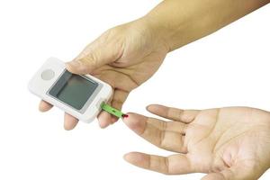 Woman is checking diabetes using blood checking kit isolated over white photo