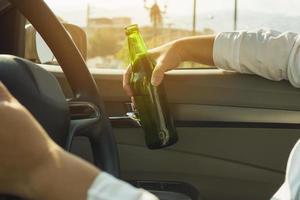 Woman drinking beer while driving a car photo