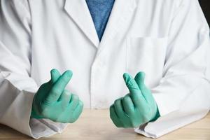 Middle part of doctor sitting and put green glove showing thumb up cheer sign photo