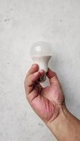 hand holding bulb on White background photo