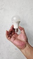 hand holding bulb on White background photo