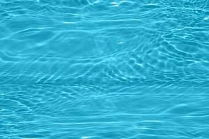 Defocus blurred blue water shining in the swimming pool. rippled water detail background. The water surface in the sea, ocean background. Water wave under sea texture background. photo