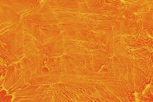 desenfoque borroso transparente color naranja claro agua tranquila textura superficial con salpicaduras y burbujas. fondo de naturaleza abstracta de moda. onda de agua a la luz del sol con espacio de copia. textura de acuarela azul foto