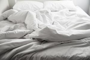 sábana de cama blanca usada en un hotel - hotel para el concepto de viaje en pareja foto