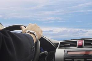 Man is driving a car in day time with blue sky and cloud background photo