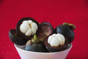 Mangosteen Thai popular fruits - a tropical fruit with sweet juicy white segments of flesh inside a thick reddish-brown rind. photo