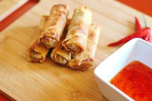 Spring rolls with chili sauce on the wooden background photo