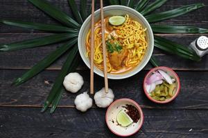 Khao Soi Recipe,Khao Soi,Khao Soi Kai, Thai Noodles Khao Soi, Chicken Curry with seasoning served on wooden table photo