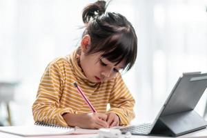 las estudiantes asiáticas en clases de aprendizaje en línea estudian en línea con tableta en casa. foto