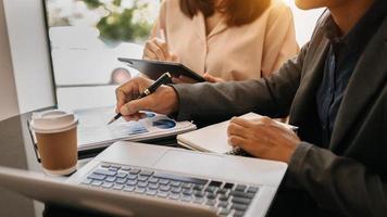 Diverse employees working on financial project statistics or report, writing notes on colorful sticky papers, checking documents,business strategy, teamwork photo