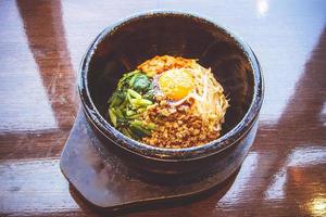 bibimbap en un cuenco de piedra calentado, comida coreana foto