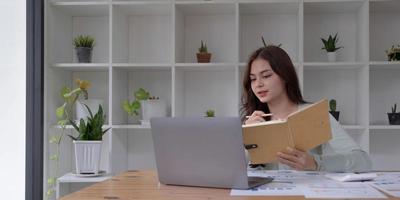 Concentrated female student busy studying using laptop make notes in notebook, focused man worker employee write watching webinar or online training course on computer, education concept photo