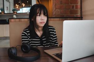 girl using computer laptop watching movie or listen music with earphone and digital internet communication social network. photo