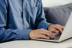 Businessman hand typing keyboard on laptop computer. Close up businessman communicating internet and social media at his desk. photo