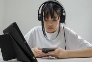 girl wearing headphones studying online with computer laptop and listen to relaxing music or play internet social media at home. photo