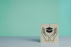 Wooden cube with graduation cap icon.Education concept. Graduation day success on background copy space. photo