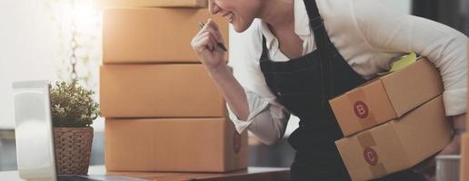 Portrait of Starting small businesses SME owners female entrepreneurs working on receipt box and check online orders to prepare to pack the boxes, sell to customers, SME business ideas online. photo