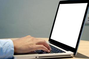 man hand using keyboard computer laptop mock up blank screen on desk. photo