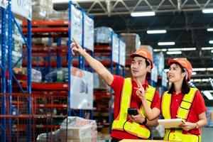 Supervisor and manager smiling happy hold scanner on hand visit warehouse as annual audit inventory stock check in large warehouse surrounding with high level of warehouse steel blue racking photo