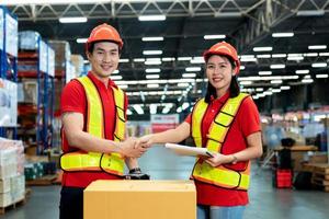 Male and female staff workers shaking hands with deals in warehouse, success collaboration concept, teamwork. photo