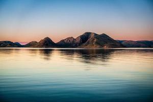 Mountains over lake at sunset photo