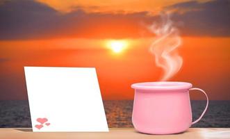 A bright pink metallic coffee cup on vacation.  And there is a blank sheet of note paper for inserting the contents. mock up and copy space photo