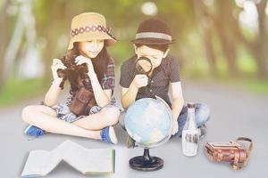 Asian boy and girl travelers are studying world map prepare to go photo