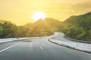 hermosa carretera de Tailandia con montaña verde y fondo de sol foto