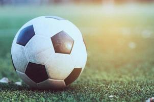 fútbol antiguo en el campo de césped artificial verde - concepto de competición de juegos deportivos de fútbol o fútbol foto