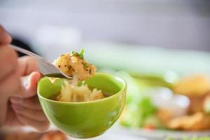 el primer plano de la gente come bistec con salchichas, patatas fritas y plato de ensalada - gente con concepto de comida rápida foto