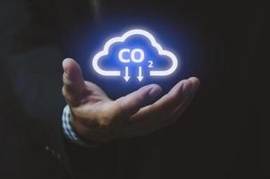 nube de icono de mano de hombre. emisiones de co2 de energía ecológica sostenible y calentamiento global con iconos de restricciones de inversión y pantalla virtual de símbolos. concepto de negocio. foto