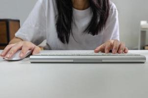 Female person holding mouse and keyboard computer. Technology internet information browsing online social media and network concept. photo