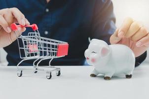 Savings retirement or investment business financial expenses marketing . businessman holding cart and piggy bank. photo