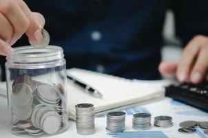 businessman is shown holding a jar with coins for savings and investments. Concept of tax payments and business accounting. photo