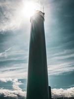 faro bajo la dura luz del sol y el cielo nublado turquesa en ostende, bélgica. foto