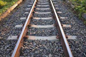 piedra negra debajo de los rieles. concepto de cimientos de construcción estables. foto