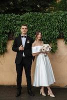 young couple bride and groom in a white short dress photo