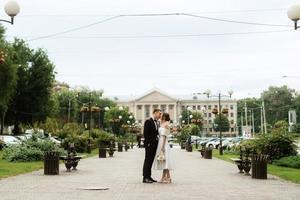 young couple bride and groom in a white short dress photo