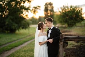 young couple the groom in a black suit and the bride in a white short dress photo