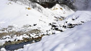 primer plano de piedra y arroyo en la niebla noboribetsu onsen foto