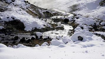 Closeup stone and stream in the mist Noboribetsu onsen snow photo