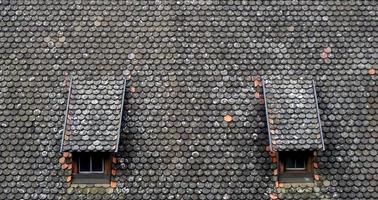 brown old ceramic tile roof top shingles middle ages with two window texture background photo