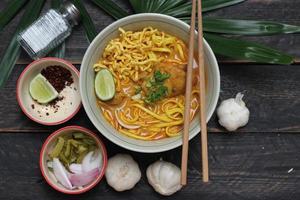 Khao Soi Recipe,Khao Soi,Khao Soi Kai, Thai Noodles Khao Soi, Chicken Curry with seasoning served on wooden table photo