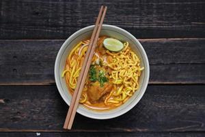 Khao Soi Recipe,Khao Soi,Khao Soi Kai, Thai Noodles Khao Soi, Chicken Curry with seasoning served on wooden table photo