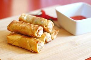 Spring rolls with chili sauce on the wooden background photo